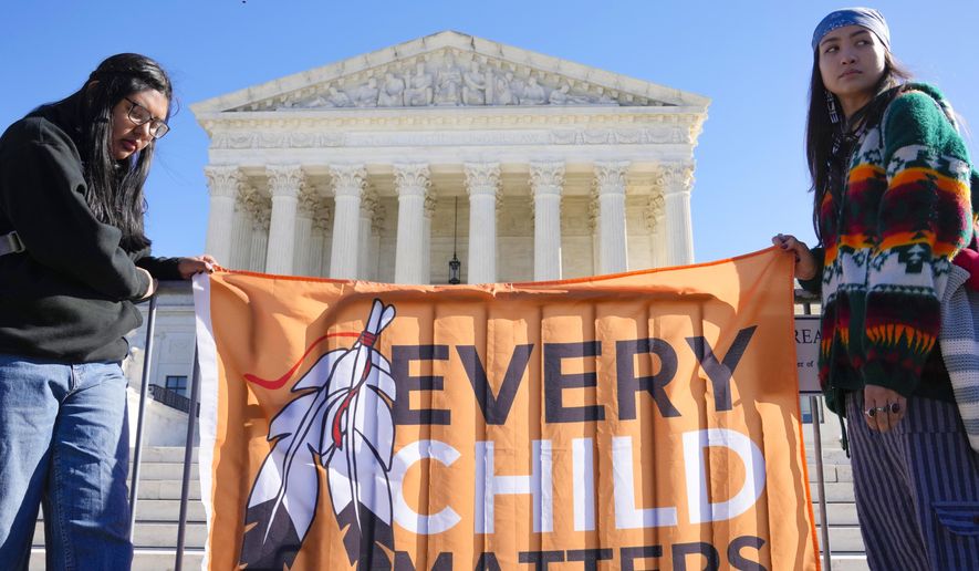Demonstrators stand outside of the U.S. Supreme Court, as the court hears arguments over the Indian Child Welfare Act on Nov. 9, 2022, in Washington. Montana Gov. Greg Gianforte has signed into law legislation Monday, May 22, 2023, that gives Native American families preference in fostering and adopting Native children involved with child protective services, as the U.S. Supreme Court considers a case that could undercut a similar federal law. (AP Photo/Mariam Zuhaib) **FILE**