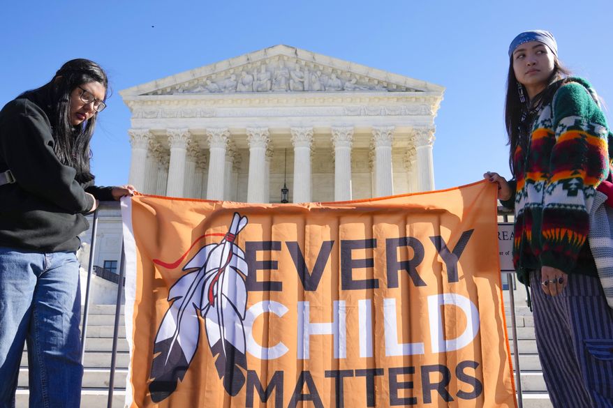 Demonstrators stand outside of the U.S. Supreme Court, as the court hears arguments over the Indian Child Welfare Act on Nov. 9, 2022, in Washington. Montana Gov. Greg Gianforte has signed into law legislation Monday, May 22, 2023, that gives Native American families preference in fostering and adopting Native children involved with child protective services, as the U.S. Supreme Court considers a case that could undercut a similar federal law. (AP Photo/Mariam Zuhaib) **FILE**