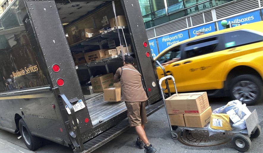 A United Parcel Service driver loads his truck, adjacent to a UPS Store, in New York, Thursday, May 11, 2023. More than 340,000 unionized United Parcel Service employees, including drivers and warehouse workers, say they are prepared to strike if the company does not meet their demands before the end of the current contract on July 31. (AP Photo/Richard Drew)