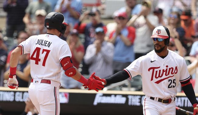 Minnesota Twins&#x27; Edouard Julien (47) high-fives Byron Buxton (25) after hitting a home run in the first inning of a baseball game against the San Francisco Giants, Wednesday, May 24, 2023, in Minneapolis. (AP Photo/Stacy Bengs)
