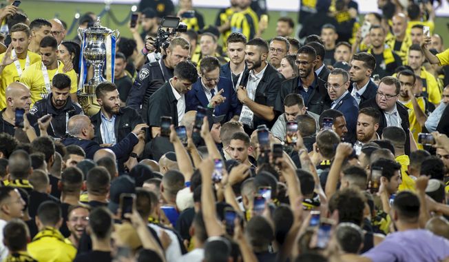 Israeli President Isaac Herzog, center, is surrounded by security on the field as fans of the Beitar Jerusalem soccer club rushed the field after their team won the State Cup finals in Haifa, Israel, Tuesday, May 23, 20230. Thousands of Beitar Jerusalem supporters charged the pitch before the trophy ceremony after the team&#x27;s 3-0 victory against Maccabi Netanya. (AP Photo/Alain Schieber)