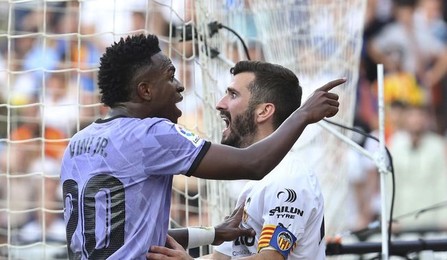 Real Madrid&#x27;s Vinicius Junior, left, confronts Valencia fans standing in front of Valencia&#x27;s Jose Luis Gaya during a Spanish La Liga soccer match between Valencia and Real Madrid, at the Mestalla stadium in Valencia, Spain, Sunday, May 21, 2023. Repeated racist insults against Brazilian soccer star Vincius Junior have unleashed a heated debate in Spain about tolerance for racism in a society that is becoming rapidly more diverse on and off the field. (AP Photo/Alberto Saiz, File)