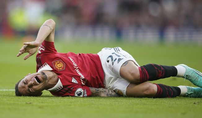 Manchester United&#x27;s Antony lies on the pitch in pain during the English Premier League soccer match between Manchester United and Chelsea at the Old Trafford stadium in Manchester, England, Thursday, May 25, 2023. (AP Photo/Dave Thompson)