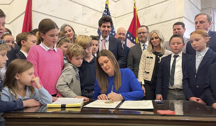 Arkansas Gov. Sarah Huckabee Sanders signs into law an education overhaul bill on Wednesday, March 8, 2023, at the state Capitol in Little Rock, Ark. As the federal government scrambles to crack down on surging child labor violations, some state lawmakers want to let children work longer hours and in more hazardous occupations. Republican Arkansas Gov. Sanders signed a law in March eliminating work permit requirements for children under 16, thereby also eliminating the age verification and parental consent required to obtain a permit. (AP Photo/Andrew DeMillo, File)