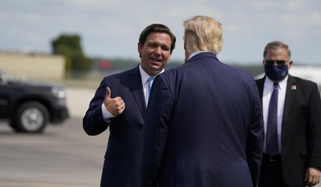 President Donald Trump speaks with Florida Gov. Ron DeSantis as he arrives at Southwest Florida International Airport, Oct. 16, 2020, in Fort Myers, Fla. (AP Photo/Evan Vucci) ** FILE **