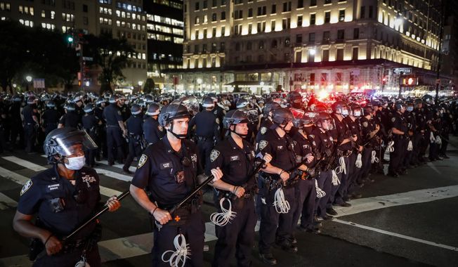 New York City Police Department officers stand in formation after arresting multiple protesters marching after curfew on Fifth Avenue on June 4, 2020, in New York, following the death of George Floyd. The third anniversary of Floyd’s murder is Thursday, May 25, 2023. (AP Photo/John Minchillo) **FILE**