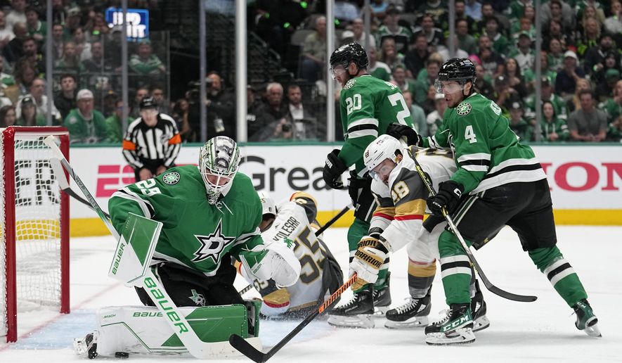 Dallas Stars goaltender Jake Oettinger (29) blocks a shot as defenseman Miro Heiskanen (4) helps against pressure from Vegas Golden Knights left wing William Carrier (28) during the second period of Game 4 of the NHL hockey Stanley Cup Western Conference finals Thursday, May 25, 2023, in Dallas. (AP Photo/Tony Gutierrez)
