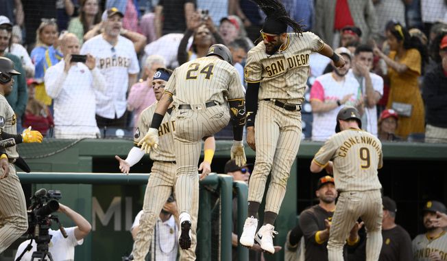 San Diego Padres&#x27; Rougned Odor (24) celebrates his three-run home run with Fernando Tatis Jr., center, during the ninth inning of the team&#x27;s baseball game against the Washington Nationals, Thursday, May 25, 2023, in Washington. The Padres won 8-6. (AP Photo/Nick Wass)