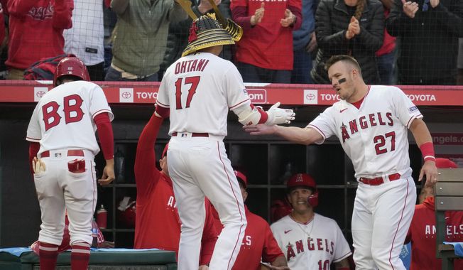 Los Angeles Angels designated hitter Shohei Ohtani (17) is greeted by Mike Trout (27) after hitting a home run during the third inning of a baseball game against the Boston Red Sox in Anaheim, Calif., Wednesday, May 24, 2023. (AP Photo/Ashley Landis)