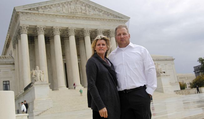 Michael and Chantell Sackett of Priest Lake, Idaho, pose for a photo in front of the Supreme Court in Washington on Oct. 14, 2011. (AP Photo/Haraz N. Ghanbari) **FILE**