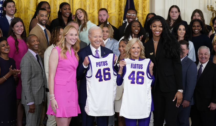 President Joe Biden and first lady Jill Biden are presented with jerseys by LSU women's basketball team captains Angel Reese, right, and Emily Ward, left, during an event to honor the 2023 NCAA national championship team in the East Room of the White House, Friday, May 26, 2023, in Washington. (AP Photo/Evan Vucci)
