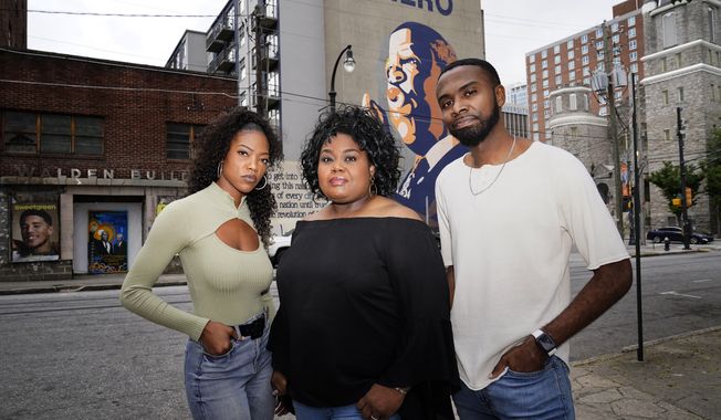 FILE - D&#x27;Zhane Parker, left, Cicley Gay, center, and Shalomyah Bowers pose for a portrait on May 13, 2022, in Atlanta. Black Lives Matter Global Network Foundation Inc., a national Black Lives Matter nonprofit, whose philanthropic fortunes grew almost overnight during historic racial justice protests three years ago, raised just over $9 million in its last fiscal year, new IRS tax filings show. Cicley Gay, board chair for the foundation, said the belt tightening was part of an effort to demonstrate that its stewards “have been responsible, proactive decision-makers of the people’s donations.” (AP Photo/Brynn Anderson, File)