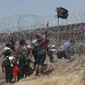 Migrants cross a barbed-wire barrier at the US-Mexico border, as seen from Ciudad Juarez, Mexico, Thursday, May 11, 2023. Migrants rushed across the Mexico border in hopes of entering the U.S. in the final hours before pandemic-related asylum restrictions are lifted. (AP Photo/Christian Chavez, File)