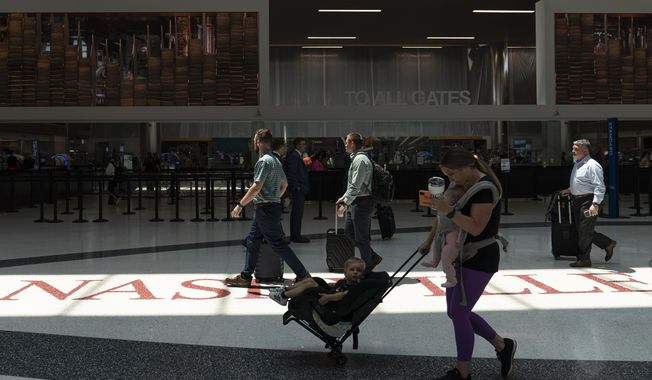 Travelers make their way through the Nashville International Airport Thursday, May 25, 2023, in Nashville, Tenn. (AP Photo/George Walker IV)