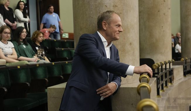 Poland&#x27;s opposition leader and former prime minister, Donald Tusk, watches lawmakers vote to approve a contentious draft law in parliament in Warsaw, Poland, on Friday, May 26, 2023. The law is for investigating Russia&#x27;s alleged influence in Poland that is targeting the opposition, especially Tusk, and may affect the outcome of fall parliamentary elections. (AP Photo/Czarek Sokolowski)