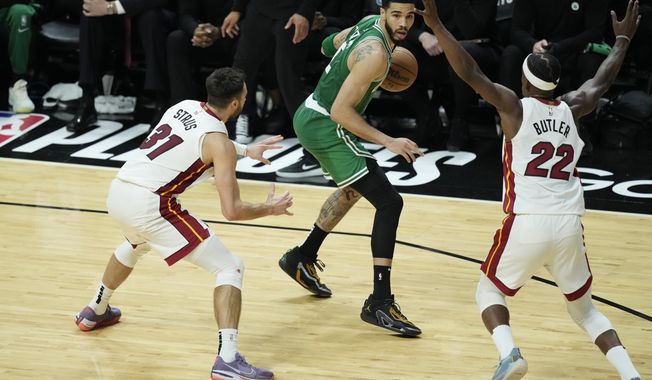 Boston Celtics forward Jayson Tatum, center, looks for an open teammate past Miami Heat forward Jimmy Butler (22) and guard Max Strus (31) during the second half of Game 6 of the NBA basketball Eastern Conference finals, Saturday, May 27, 2023, in Miami. (AP Photo/Rebecca Blackwell)