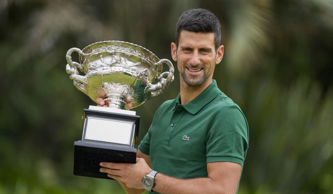 Novak Djokovic of Serbia poses with the Norman Brookes Challenge Cup in the gardens of Government House the morning after defeating Stefanos Tsitsipas of Greece in the men&#x27;s singles final at the Australian Open tennis championship in Melbourne, Australia, Monday, Jan. 30, 2023. Novak Djokovic has made his long-term goal clear: He wanted to focus on accumulating Grand Slam titles in order to surpass the trophy total of rivals Rafael Nadal and Roger Federer. With the French Open set to start Sunday, May 28, 2023 without either the injured Nadal or the retired Federer, Djokovic gets the chance to finally lead the career standings alone with a men’s-record 23 if he winds up with the championship two weeks from now. (AP Photo/Mark Baker, File)
