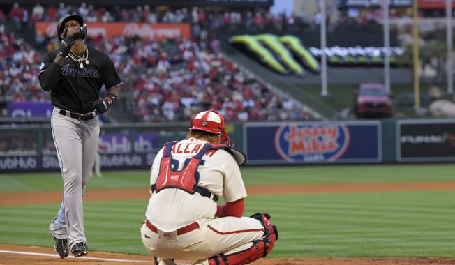 Miami Marlins&#x27; Jorge Soler, left, gestures as he scores after hitting a solo home run as Los Angeles Angels catcher Chad Wallach kneels at the plate during the third inning of a baseball game Friday, May 26, 2023, in Anaheim, Calif. (AP Photo/Mark J. Terrill)
