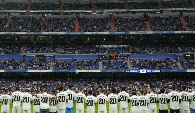 Players of Real Madrid wear jerseys with the name of team mate Vinicius Junior for a Spanish La Liga soccer match between Real Madrid and Rayo Vallecano at the Santiago Bernabeu stadium in Madrid, Spain, Wednesday, May 24, 2023. (AP Photo/Manu Fernandez)