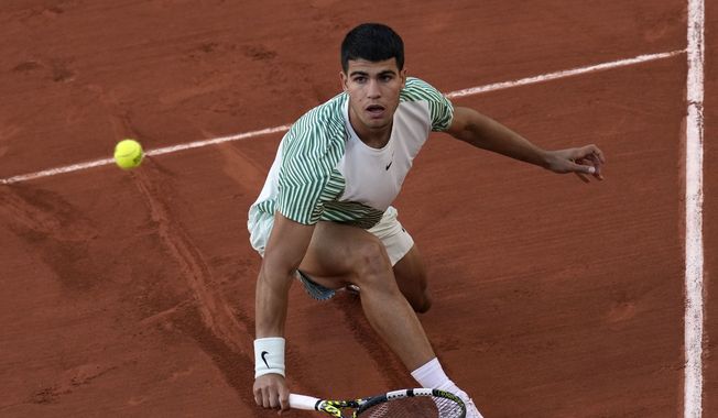 Spain&#x27;s Carlos Alcaraz plays a shot against Italy&#x27;s Flavio Cobolli during their first round match of the French Open tennis tournament at the Roland Garros stadium in Paris, Monday, May 29, 2023. (AP Photo/Christophe Ena)