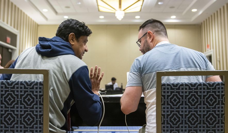 Mirle Shivashankar and Kevin Moch talk during a meeting of the word panel to finalize the 2023 Scripps National Spelling Bee words on Sunday, May 28, 2023, at National Harbor in Oxon Hill, Md. (AP Photo/Nathan Howard)