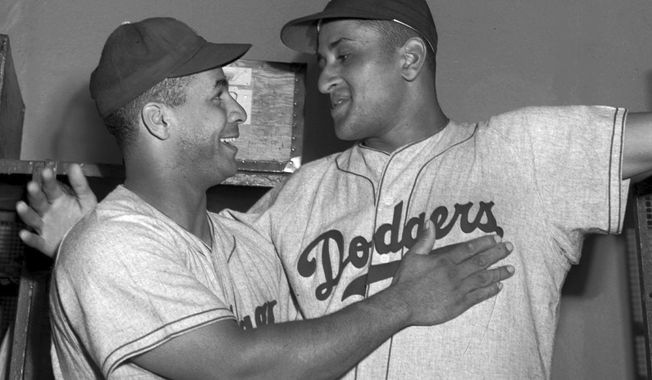 Brooklyn Dodgers catcher Roy Campanella, left, congratulates his battery mate, Don Newcombe, in the dressing room at the Polo Grounds in New York on Sept. 2, 1949. Holman Stadium in Nashua, N.H., is being recognized for hosting the country&#x27;s first racially integrated baseball team, the Nashua Dodgers, in 1946. The club was a minor league league affiliate of the Dodgers, which included Hall of Famer Campanella and future Cy Young Award winner Newcombe. (AP Photo/Matty Zimmern, File)