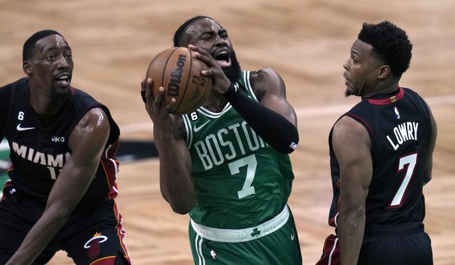Boston Celtics guard Jaylen Brown, center, shoots as Miami Heat center Bam Adebayo left, and guard Kyle Lowry defend during the first half in Game 7 of the NBA basketball Eastern Conference finals Monday, May 29, 2023, in Boston. (AP Photo/Charles Krupa )
