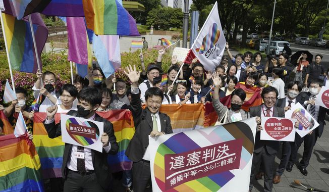 Lawyers of plaintiffs and supporters celebrate following a ruling in front of the Nagoya District Court in Nagoya, central Japan Tuesday, May 30, 2023. The Japanese court on Tuesday found the government policy of not allowing same-sex marriage unconstitutional, a closely watched ruling that could give a push toward achieving marriage equality in a country that still resists anti-discrimination law for LGBTQ+ rights. A banner, center, reads &quot;unconstitutional judgment.&quot; (Kyodo News via AP)