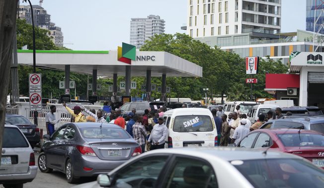 People queue to buy fuel at the Nigerian National Petroleum Company Limited petrol station in Lagos, Nigeria, Tuesday, May 30, 2023. Nigerian President Bola Tinubu has scrapped a decadeslong government-funded subsidy that has helped reduce the price of gasoline, leading to long lines at fuel stations Tuesday as drivers scrambled to stock up before costs rise. (AP Photo/Sunday Alamba)