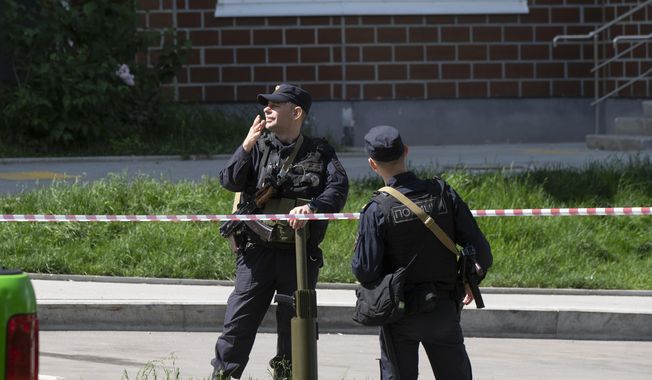 Police officers guard an area where a Ukrainian drone damaged an apartment building in Moscow, Russia, Tuesday, May 30, 2023. In Moscow, residents reported hearing explosions and Mayor Sergei Sobyanin later confirmed there had been a drone attack that he said caused &quot;insignificant&quot; damage. (AP Photo)