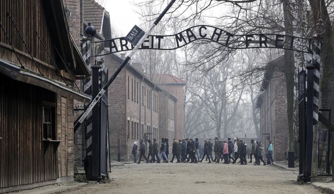 People visit the Nazi concentration camp Auschwitz-Birkenau in Oswiecim, Poland, on Friday, Feb. 15, 2019. The Auschwitz-Birkenau memorial museum has denounced a political spot by Poland&#x27;s ruling party that uses the theme of the Nazi German extermination camp to discourage participation in an upcoming anti-government march. (AP Photo/Michael Sohn, File)