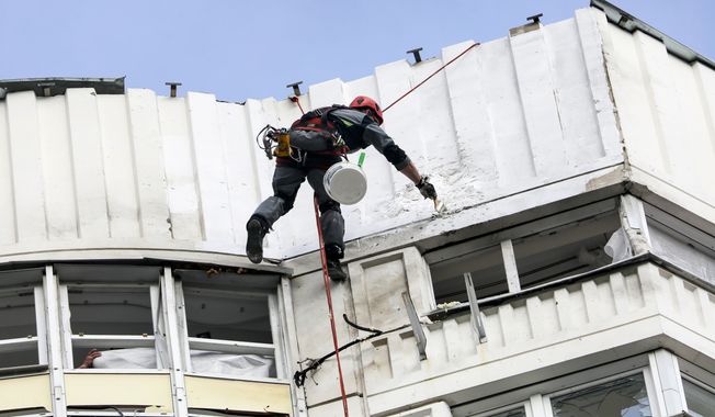 A worker repairs a damage on a building in Moscow, Russia, Tuesday, May 30, 2023 after a Ukrainian drone attack. A rare drone attack jolted Moscow before dawn, causing only light damage but forcing evacuations as residential buildings were struck in the Russian capital. (Sofia Sandurskaya, Moscow News Agency photo via AP)
