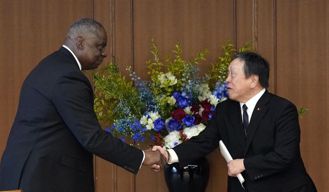 U.S. Defense Secretary Lloyd Austin, left, and Japanese Defense Minister Yasukazu Hamada shake hands at the end of a joint press conference after their meeting at the Defense Ministry in Tokyo Thursday, June 1, 2023. (Franck Robichon/Pool Photo via AP)