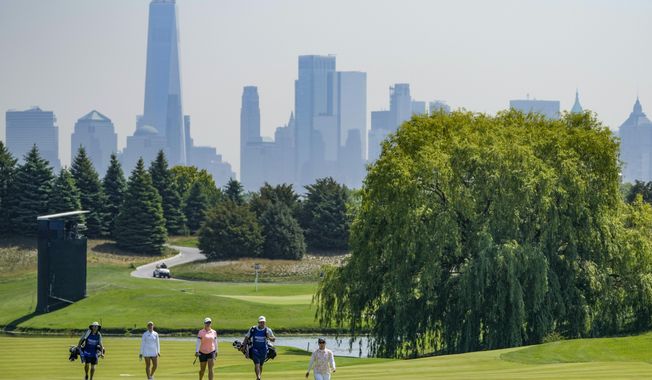 Nasa Hataoka, of Japan, center, walks up the ninth fairway during the first round of the Mizuho Americas Open golf tournament, Thursday, June 1, 2023, at Liberty National Golf Course in Jersey City, N.J. (AP Photo/John Minchillo)