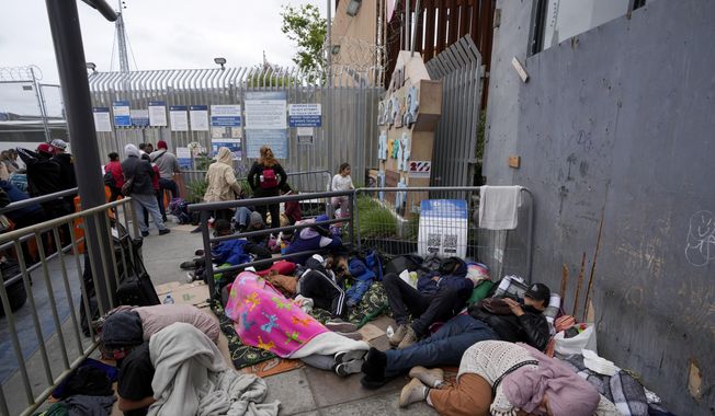 People waiting to apply for asylum camp near the pedestrian entrance to the San Isidro Port of Entry, linking Tijuana, Mexico with San Diego, Thursday, June 1, 2023, in Tijuana, Mexico. U.S. authorities raised the number of people allowed to enter the country with an online app allows asylum-seekers to enter the country with appointments to 1,250 a day from 1,000 though demand still far outstrips supply. (AP Photo/Gregory Bull)