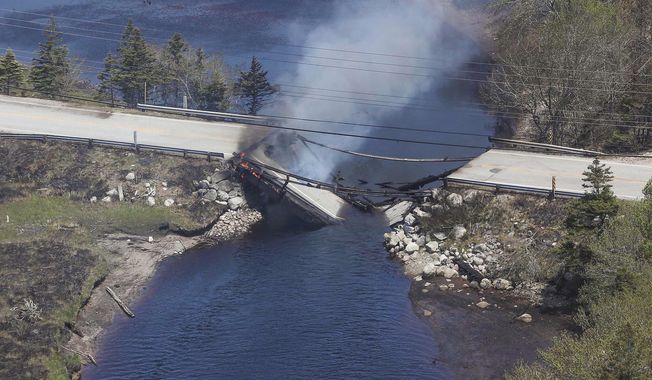 In this aerial image, collapsed bridge between the Clyde River and Port Clyde as wildfires burn in Nova Scotia, Wednesday, May 31, 2023 . (Communications Nova Scotia/The Canadian Press via AP)