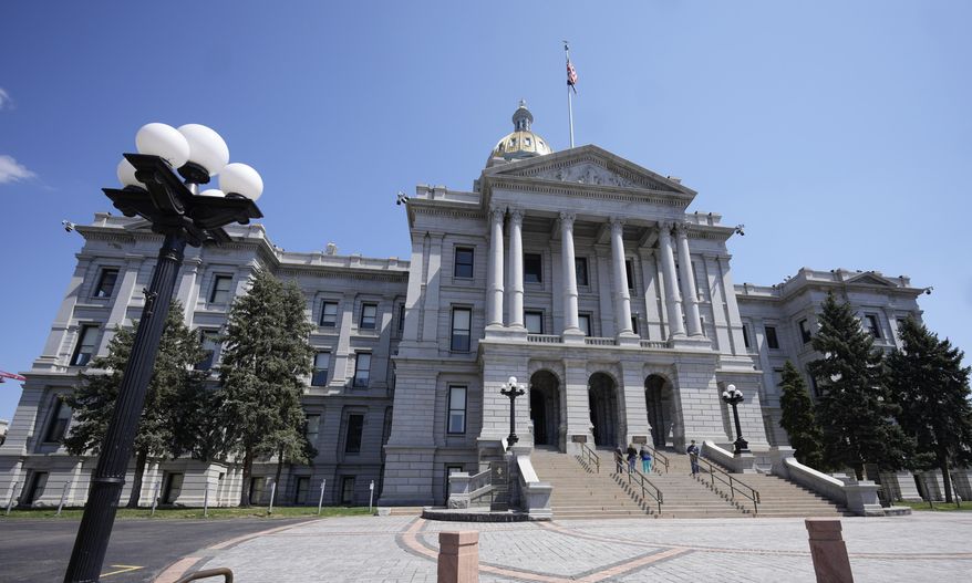 Visitors stand on the west steps of the Colorado State Capitol on April 23, 2023, in Denver. Colorado Gov. Jared Polis signed a bill Friday, June 2, banning so-called ghost guns, build-at-home firearms without serial numbers. Ghost guns, which have exploded in popularity in recent years, allow buyers to evade background checks and impede law enforcements ability to trace a firearm's origin. (AP Photo/David Zalubowski) **FILE**