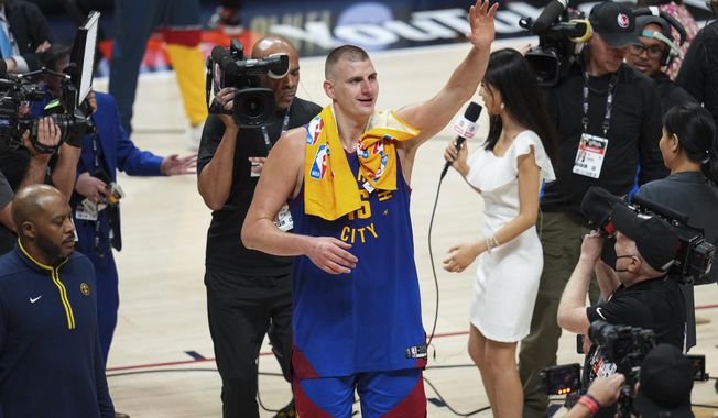 Denver Nuggets center Nikola Jokic, center, gestures to fans after the team&#x27;s 104-93 victory over the Miami Heat in Game 1 of basketball&#x27;s NBA Finals, Thursday, June 1, 2023, in Denver. (AP Photo/Jack Dempsey)