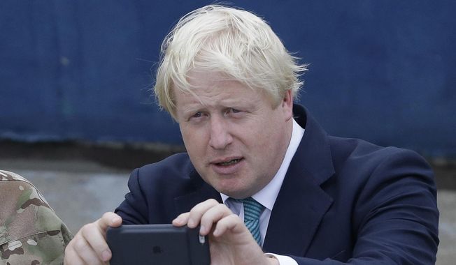 British Foreign Secretary Boris Johnson, right, takes a photo of a Nigeria Naval worship with his phone camera, during a visit to the Nigeria Navy at the Naval dockyard in Lagos, Nigeria Thursday, Aug. 31, 2017. The British government is facing a Thursday deadline to hand over a sheaf of former Prime Minister Boris Johnson’s personal messages to the country’s COVID-19 pandemic inquiry. (AP Photo/ Sunday Alamba, File)