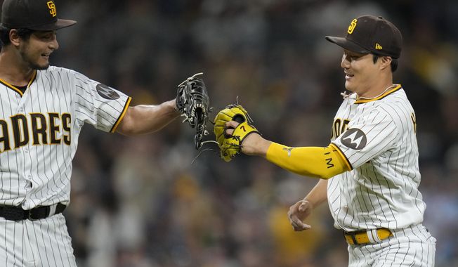 San Diego Padres second baseman Ha-Seong Kim, right, touches gloves with starting pitcher Yu Darvish after Kim threw to first for the out on Chicago Cubs&#x27; Dansby Swanson during the fourth inning of a baseball game Saturday, June 3, 2023, in San Diego. (AP Photo/Gregory Bull)