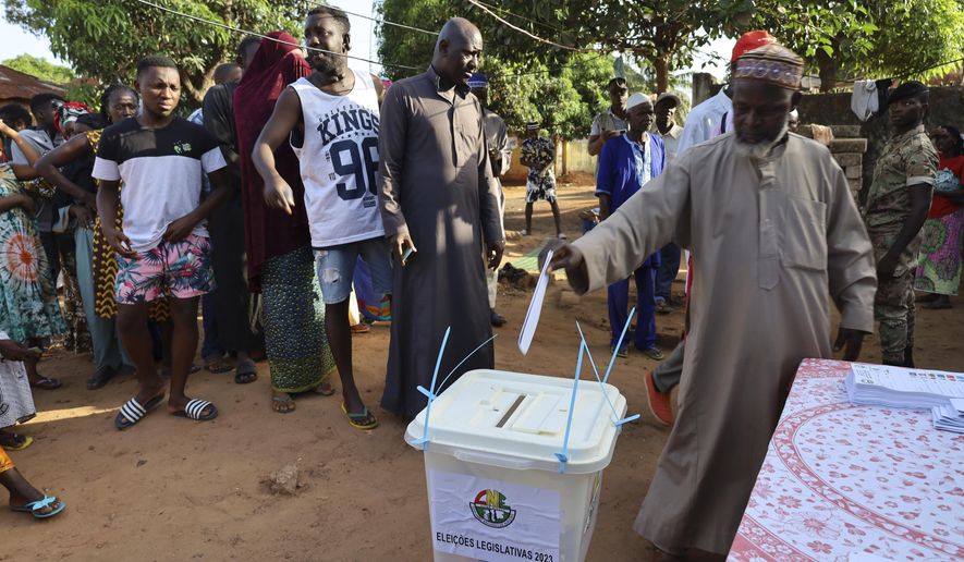 People line up to cast their ballots in Guinea-Bissau's legislative elections in Bissau, Sunday June 4, 2023. The Centre for Democracy and Development, an African human rights organisation, said nearly 1 million voters were registered to elect more than 100 lawmakers from six parties with active seats in the National People's Assembly. (AP Photo/Darcicio Barbosa)