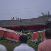 People look at the mangled wreckage of the two passenger trains that derailed Friday in Balasore district, in the eastern state of Orissa, India, Sunday, June 4, 2023. The derailment in eastern India that killed 275 people and injured hundreds was caused by an error in the electronic signaling system that led a train to wrongly change tracks and crash into a freight train, officials said Sunday. (AP Photo/Rafiq Maqbool)