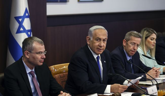 Israeli Prime Minister Benjamin Netanyahu, center, attends a weekly cabinet meeting in the prime minister&#x27;s office in Jerusalem, Sunday June 4, 2023. (Ronen Zvulun/Pool via AP)