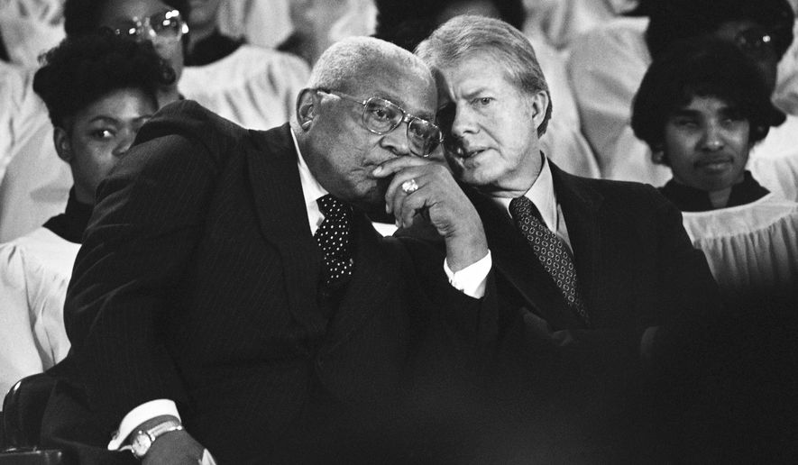 The Rev. Martin Luther King Sr. and President Jimmy Carter, right, confer during a ceremony in Atlanta on Jan. 14, 1979, to present the Dr. Martin Luther King Jr. Non-Violent Peace Prize to Carter. (AP Photo/Jim Wells, File)