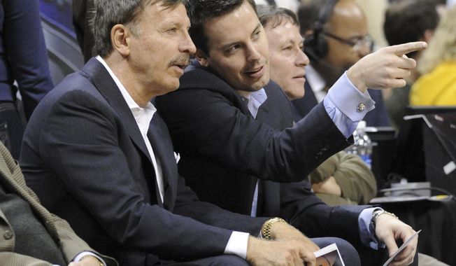 Stan Kroenke, left, owner of the Denver Nuggets, and his son Josh Kroenke watch during the first quarter of an NBA basketball game between the Nuggets and the San Antonio Spurs on March 23, 2011, in Denver. Stan Kroenke&#x27;s deal to purchase the Nuggets, along with the Colorado Avalanche and their home arena for $450 million, included a clause that tethered the NBA franchise to Denver for the ensuing 25 years. These days, the Nuggets are estimated by Forbes to be worth $1.93 billion. And all talk of them relocating no longer exists. (AP Photo/Jack Dempsey, File)