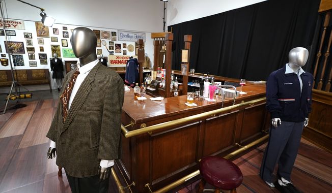The bar used on the set of the television series &quot;Cheers&quot; and some costumes worn by actors on the sitcom are shown, Thursday, April 27, 2023, in Irving, Texas. A dizzying number of props, sets, and costumes from television shows beloved by generations of viewers will be sold at auction next month. The collection James Comisar has spent over 30 years amassing includes &quot;The Tonight Show&quot; set Johnny Carson gave him after retiring, the timeworn living room from &quot;All in the Family,&quot; and the bar where Sam Malone served customers on Cheers. (AP Photo/Tony Gutierrez)