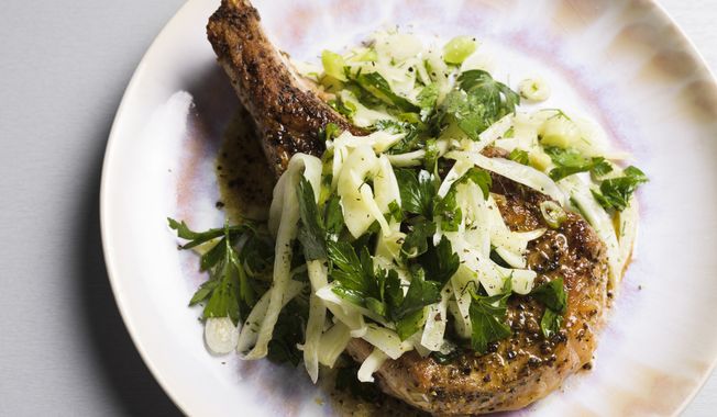 This image released by Milk Street shows a recipe for seared pork chops with a fennel and herb salad. (Milk Street via AP)