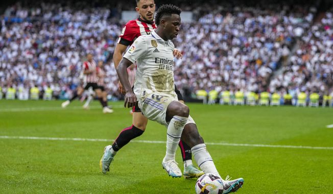 Real Madrid&#x27;s Vinicius Junior, foreground, duels for the ball with Athletic Bilbao&#x27;s Aitor Paredes during the Spanish La Liga soccer match at the Santiago Bernabeu stadium in Madrid, Sunday, June 4, 2023. (AP Photo/Bernat Armangue)