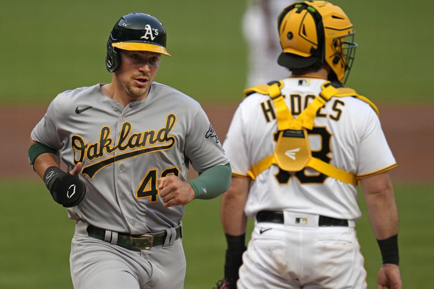 Oakland Athletics' Ryan Noda, left, scores past Pittsburgh Pirates catcher Austin Hedges on a double by Seth Brown off Pirates starting pitcher Mitch Keller, during the third inning of a baseball game in Pittsburgh, Tuesday, June 6, 2023. (AP Photo/Gene J. Puskar)