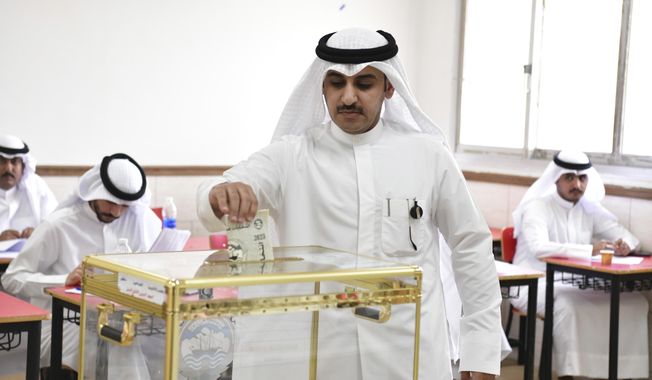 A man casts his vote for National Assembly elections at a religious school in Sabahiya district, Kuwait, Tuesday, June 6, 2022. Voters in Kuwait are casting ballots on Tuesday for a third time in as many years, with little hope of ending a prolonged gridlock between the ruling family and assertive lawmakers after the judiciary dissolved the legislature earlier this year. (AP Photo/Jaber Abdulkhaleg)
